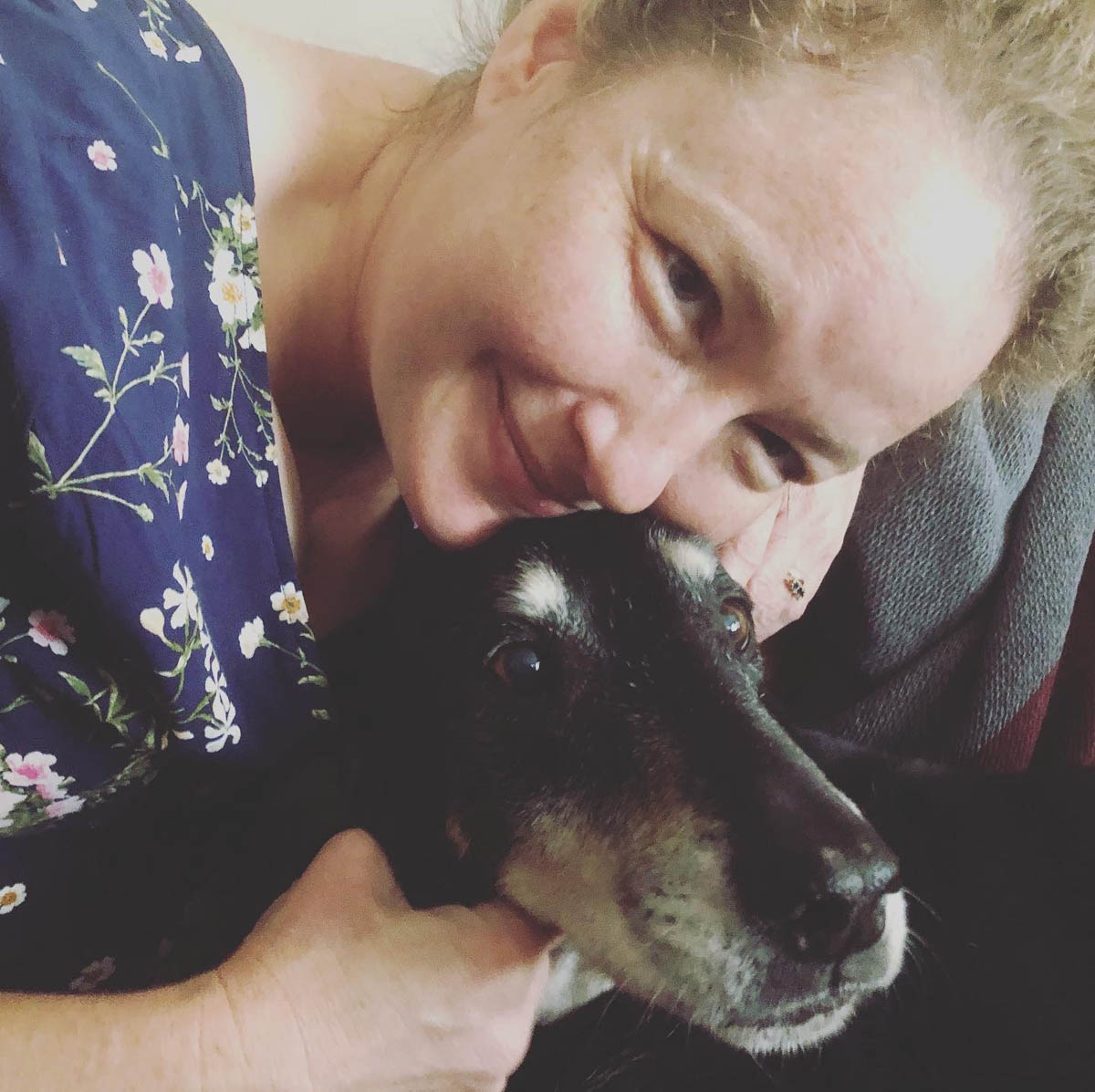 Bessie the big black dog snuggling with the human lady