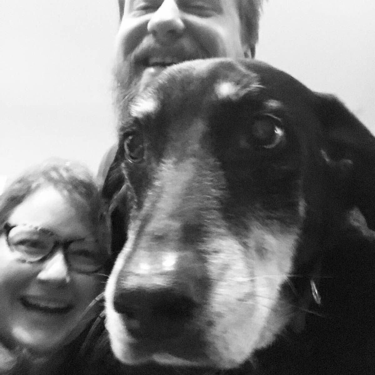 Bessie the big black dog taking a selfie with her humans