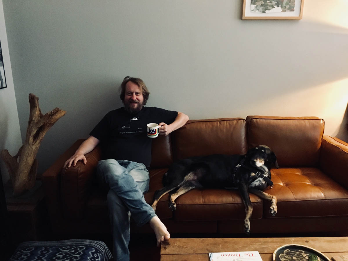 Bessie the big black dog chilling with her human on the couch