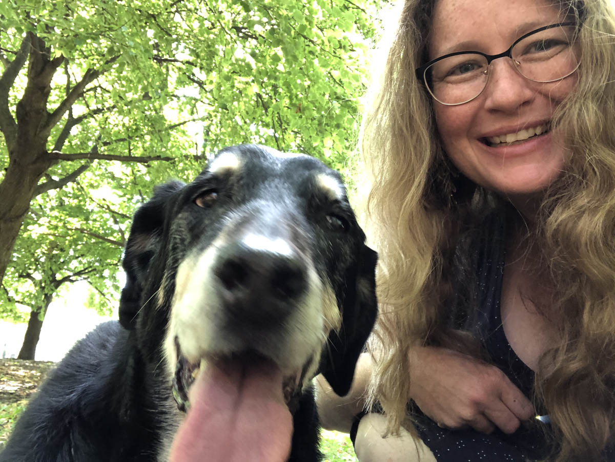 Bessie the big black dog taking a selfie with human lady in the park