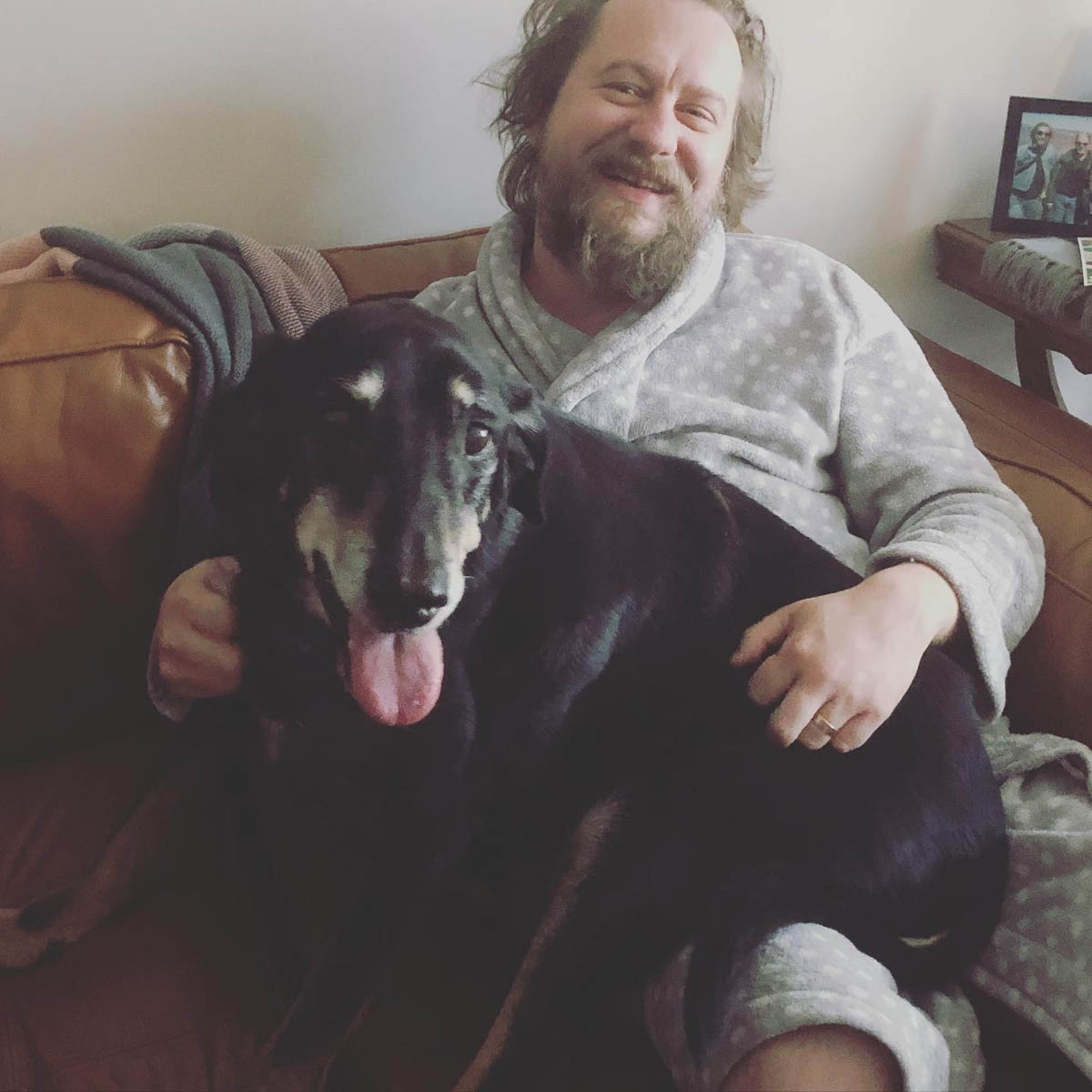 Bessie the big black dog being a lap dog and squishing the human